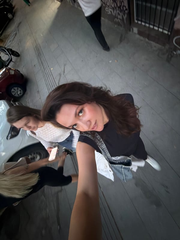 Young women take selfies while walking Belgrade sidewalk
