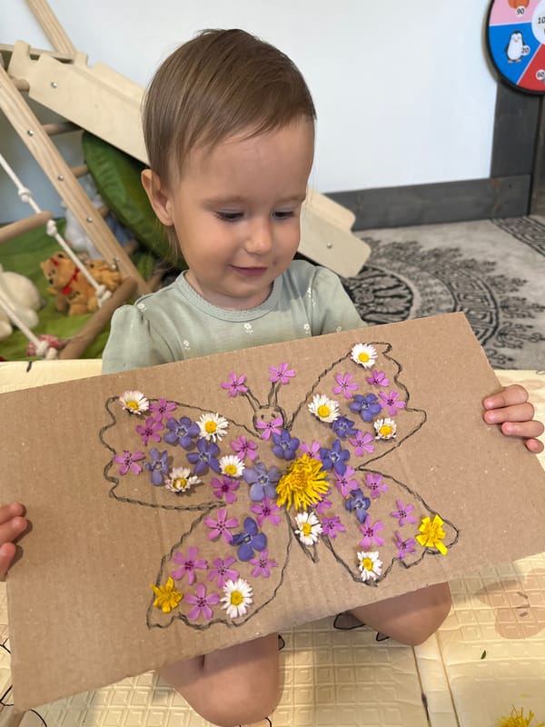 Toddler creates flower butterfly art in Wisła play area