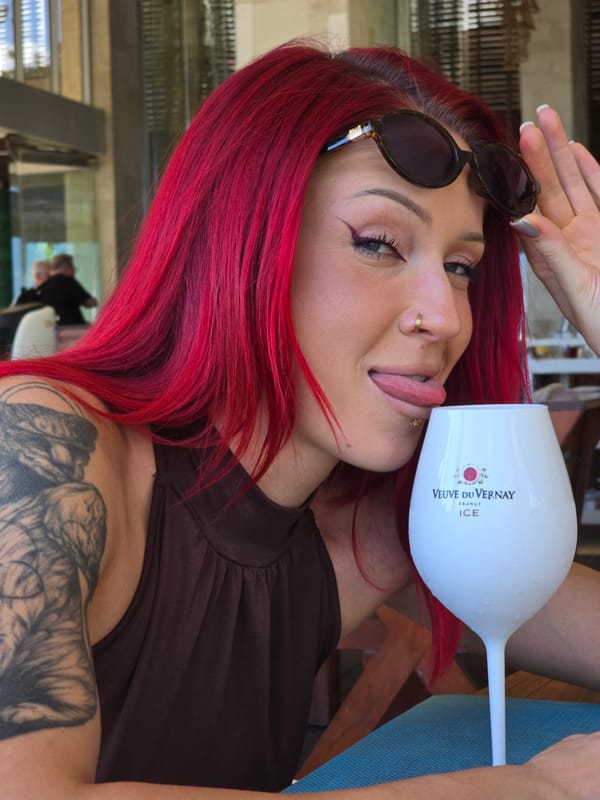 Red-haired woman poses with wine glass in North Kuta