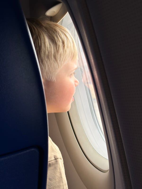 Child rests against airplane seat near window in Russia