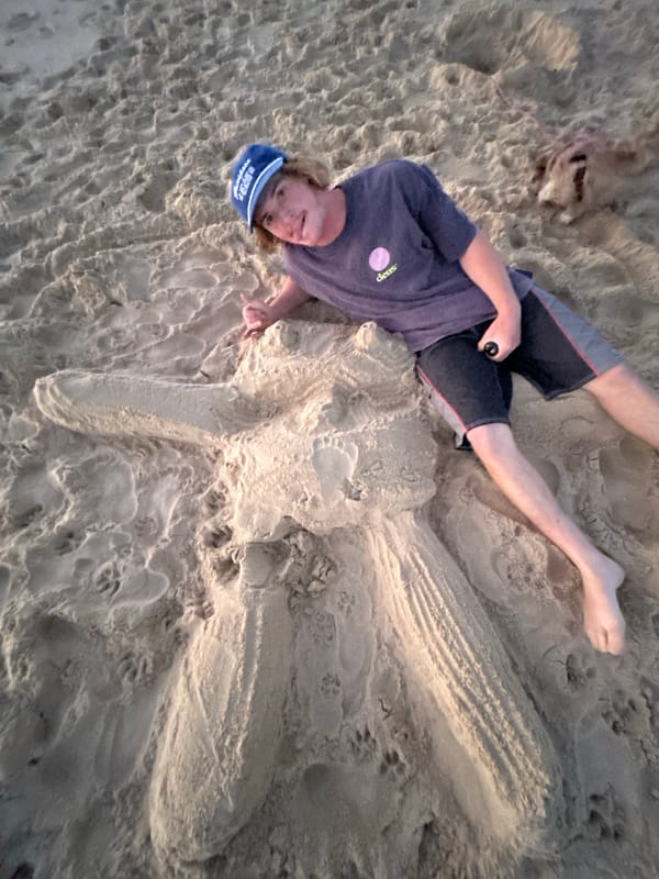 Person resting on beach leaves body impression in sand