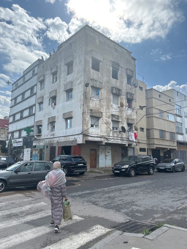 Woman crosses street in Casablanca carrying green bag