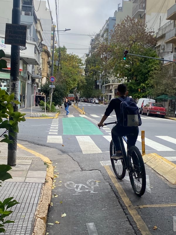 Cyclist rides through Buenos Aires street under overcast skies