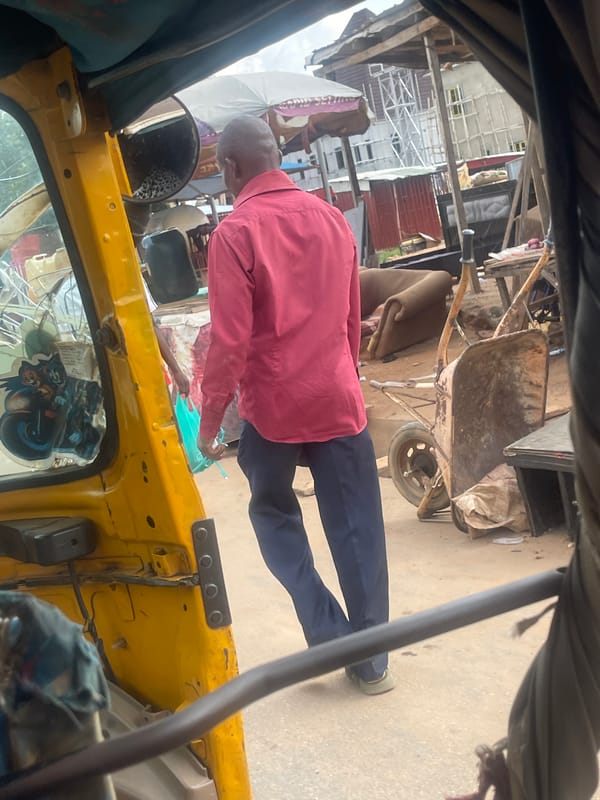 Street life around a yellow auto-rickshaw in Abuja construction zone