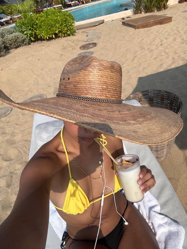 Beachgoer relaxes with drinks and phone in El Jícaro