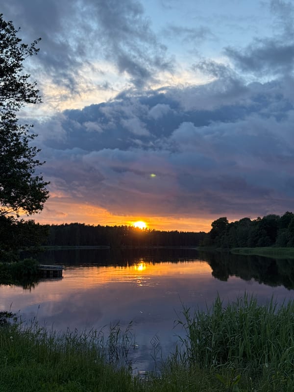 Sunset fades to twilight over calm water in Carnikava