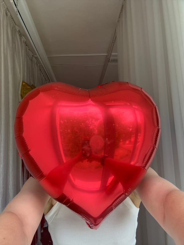 Woman poses with heart balloon, chihuahua in Chaikovsky home