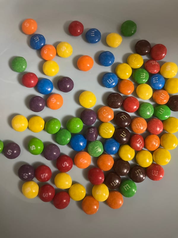 Scattered M&Ms and computer mouse observed on home surfaces