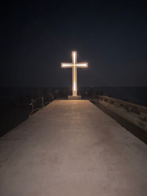 Varna waterfront at night: glowing pier cross and boardwalk stroll