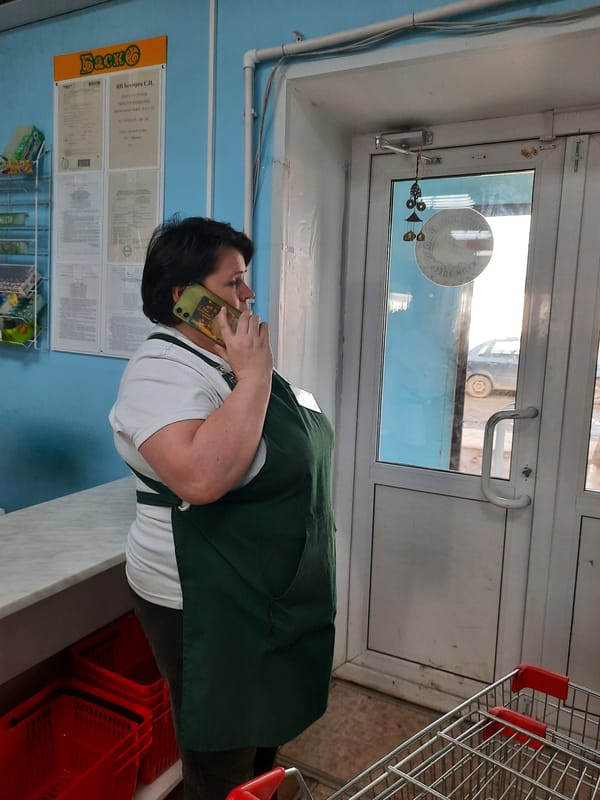 Woman takes phone call in Krasnogorskoye store amid spring thaw