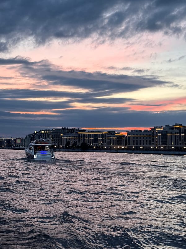 Evening boat party drifting past Saint Petersburg's lit waterfront