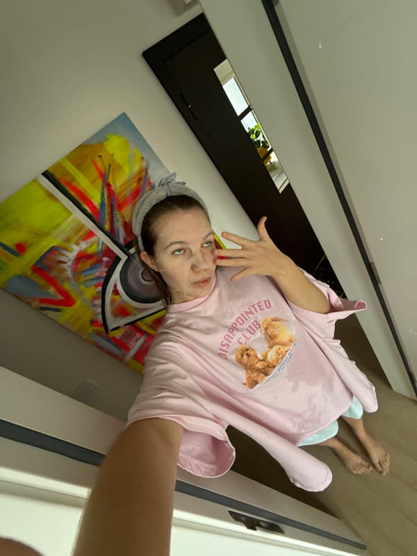 Woman in pink cat shirt drinks coffee indoors Belgrade morning