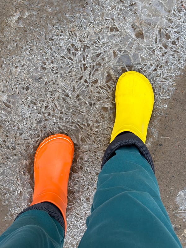 Woman in mismatched boots walks through puddles in Russia
