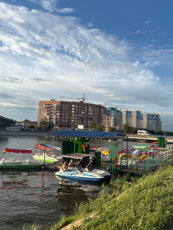 Astrakhan waterfront on a summer afternoon — boats, ponies, church domes