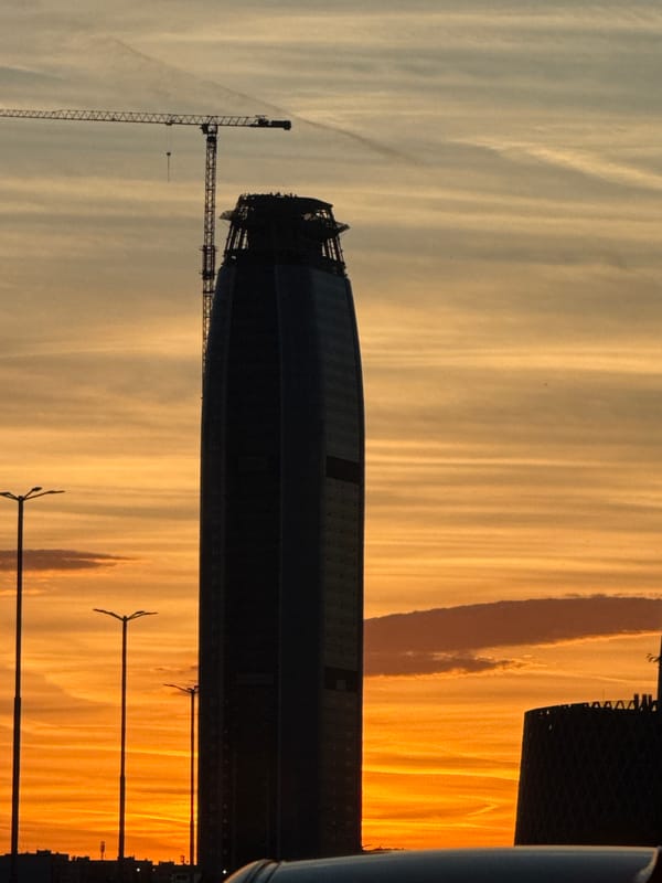 Construction site silhouetted against sunset sky in Sofia