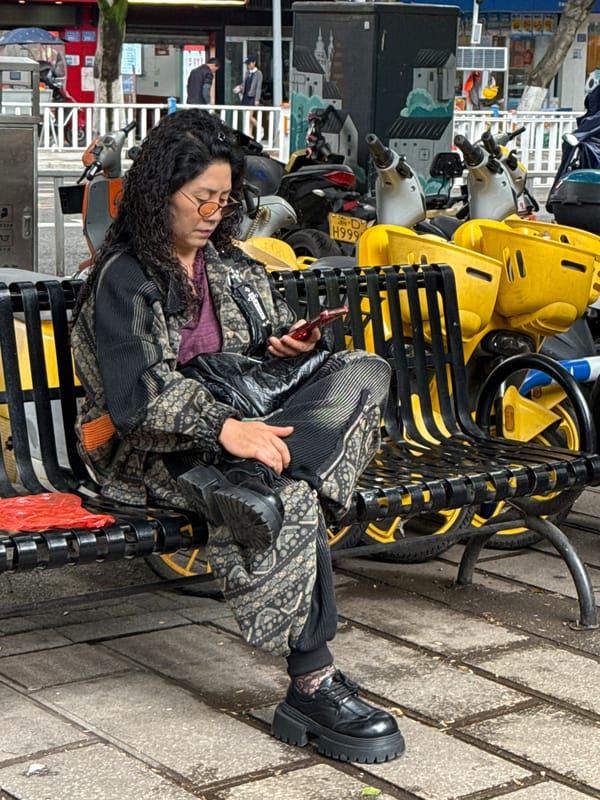 Woman sits on bicycle rack in Shapingba District