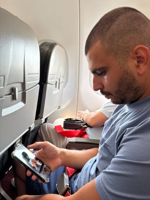 Airline passenger views photos on phone during flight