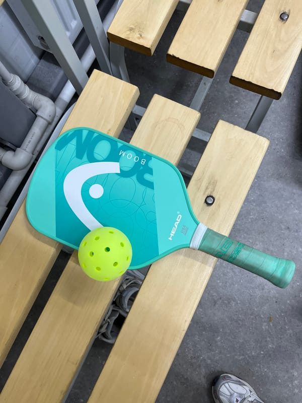Pickleball equipment spotted on wooden bench