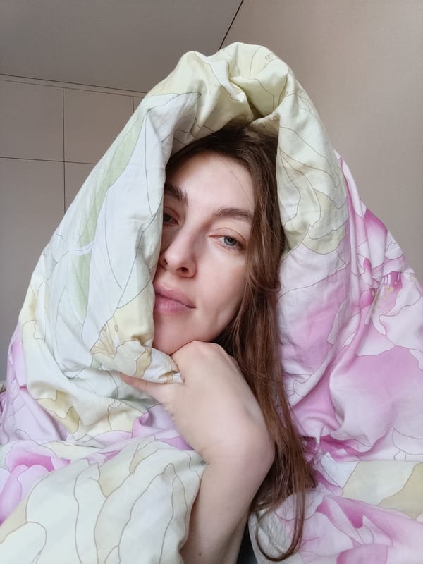 Woman photographed in bed, cat by window in Chaikovsky