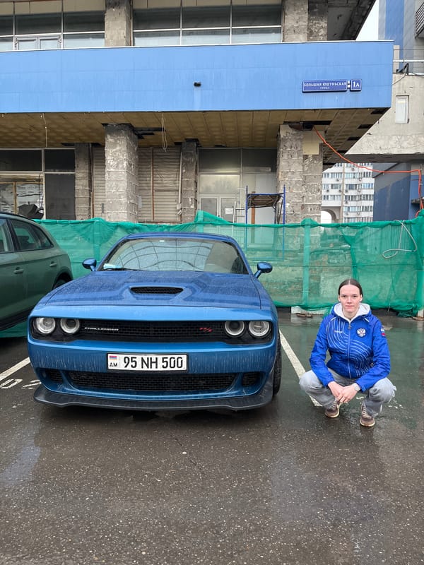 Woman poses with blue Dodge Challenger in Moscow