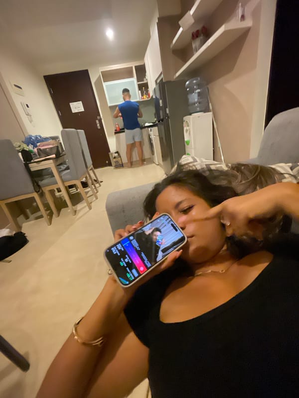 Couple relaxes on couch with phones in Jakarta apartment