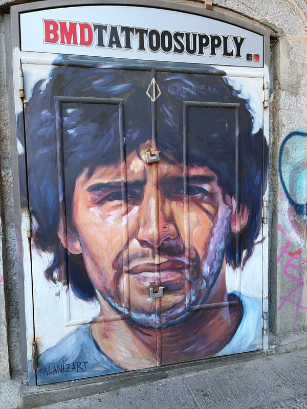 Street art portrait painted on utility panel in Naples