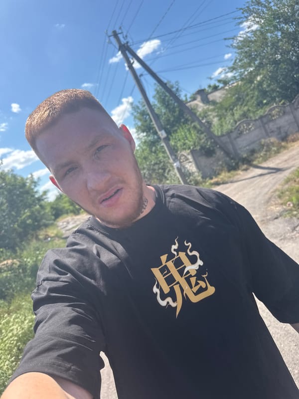 Selfies on a muddy dirt road, black tee with gold graphic