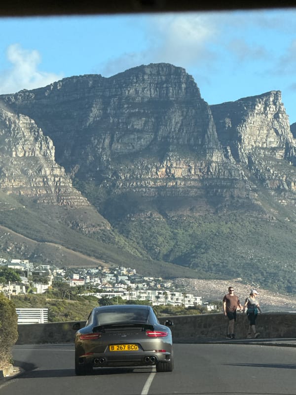 Two people pause roadside near Table Mountain, Cape Town