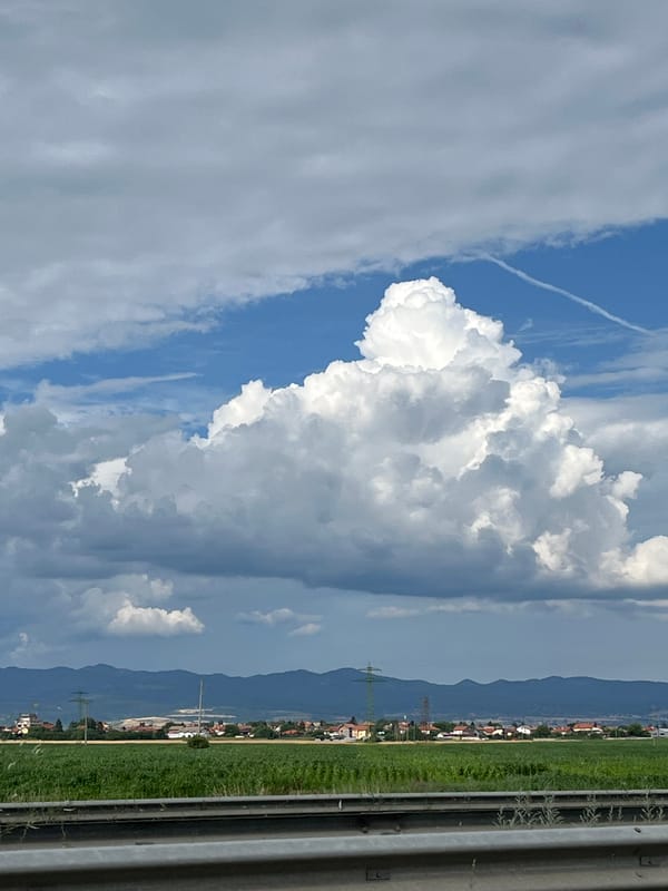 Highway drive with big skies and a low-flying plane