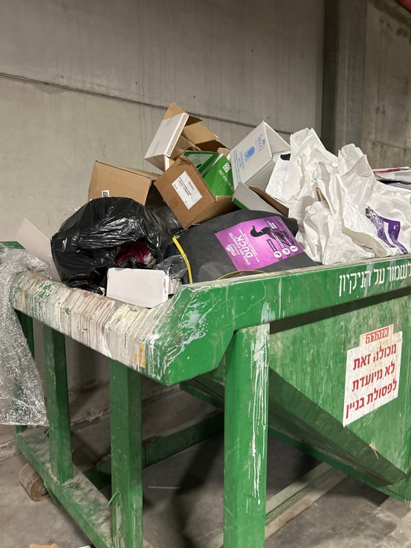 Overflowing dumpster in a Holon back alley