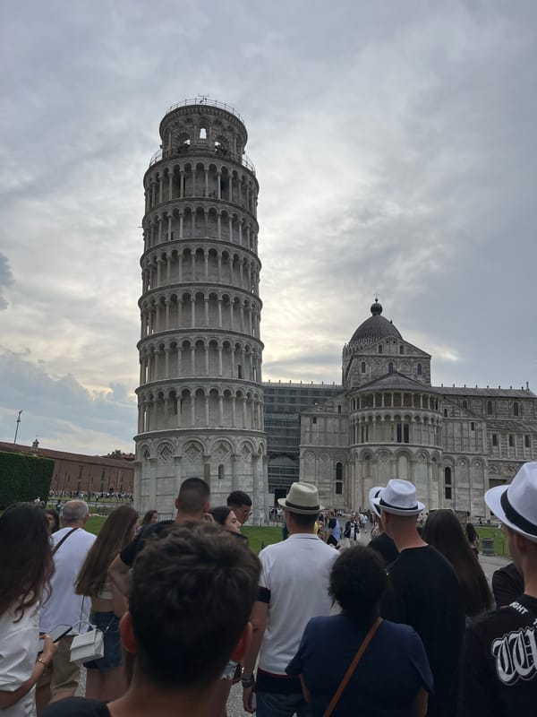 Tourists pose and take selfies at Leaning Tower of Pisa