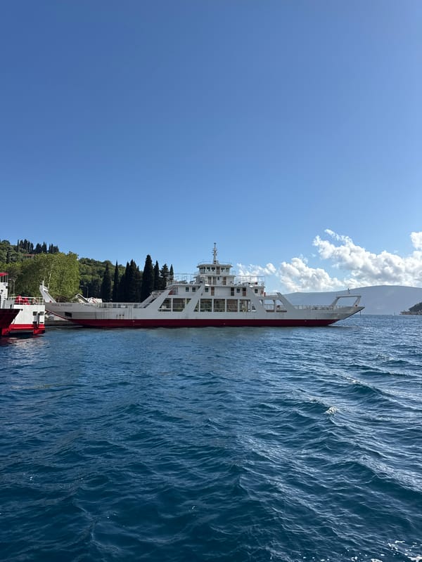 Ferry docked at Lepetane Montenegro waterfront amid stone buildings