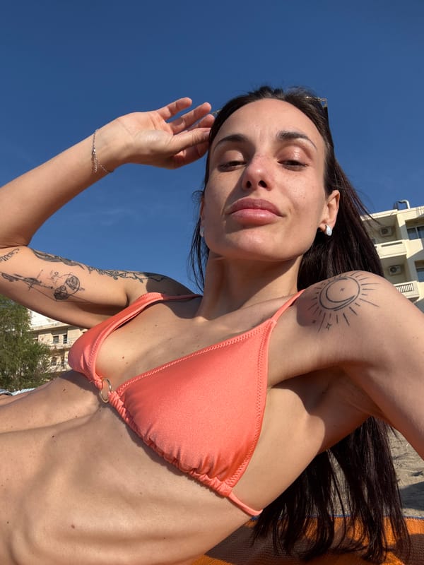 Woman in polka-dot shorts walks Chania beach