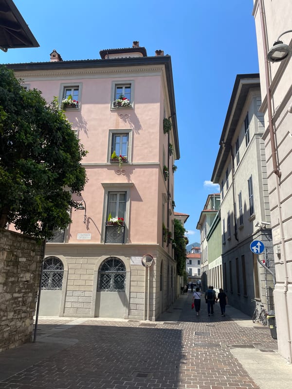 Street scene documented in Como showing pink building with flowers