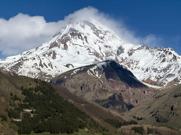 Snow-capped Mount Kazbek observed with clouded summit near Stepantsminda