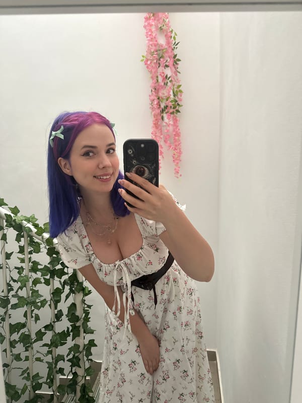 Woman takes mirror selfies in colorful hair and floral dress