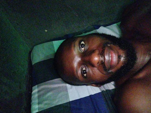 Man rests in green-lit room in Uyo, Nigeria