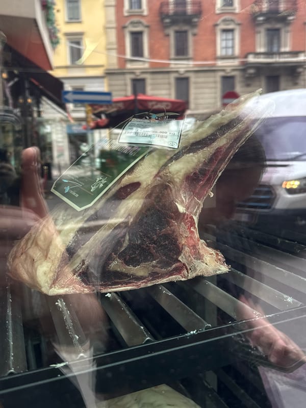 Raw beef cut displayed behind glass in Milan butcher shop