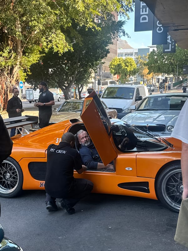 Luxury cars gather with pit crew activity in Cape Town