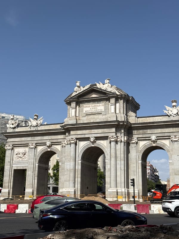 Puerta de Alcalá and a domed church on a clear Madrid afternoon
