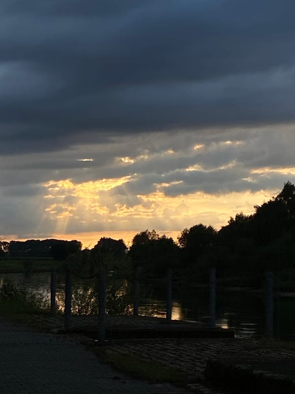 Storm clouds and golden light over the Weser at dusk