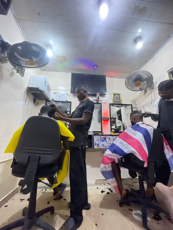 Busy barbershop serves customers in Ado, Nigeria alleyway