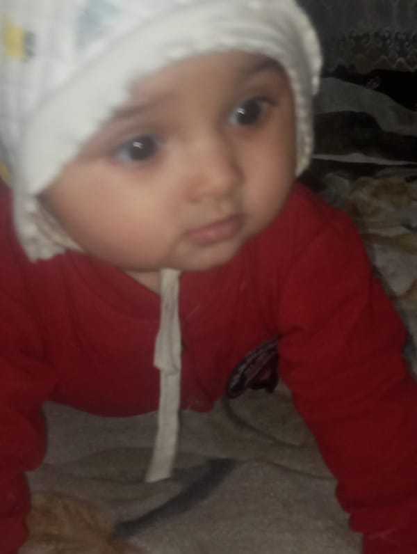 Baby in white cap, red shirt observed on surface