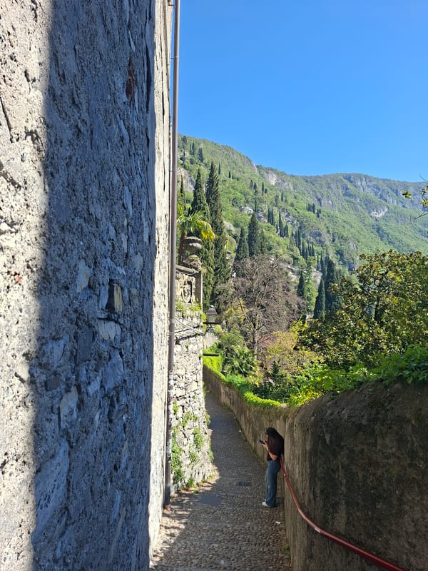 Person walks cobblestone path in Varenna, Italy