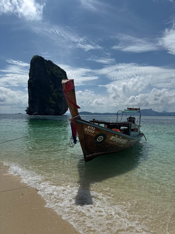 Longtail boat at Ban Ao Nang beach with limestone cliffs