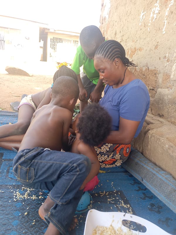 Three men at market stall in Akwanga, Nigeria
