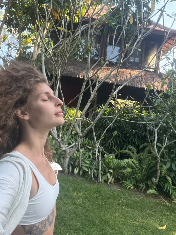 Woman photographs herself in tropical Indonesian garden setting
