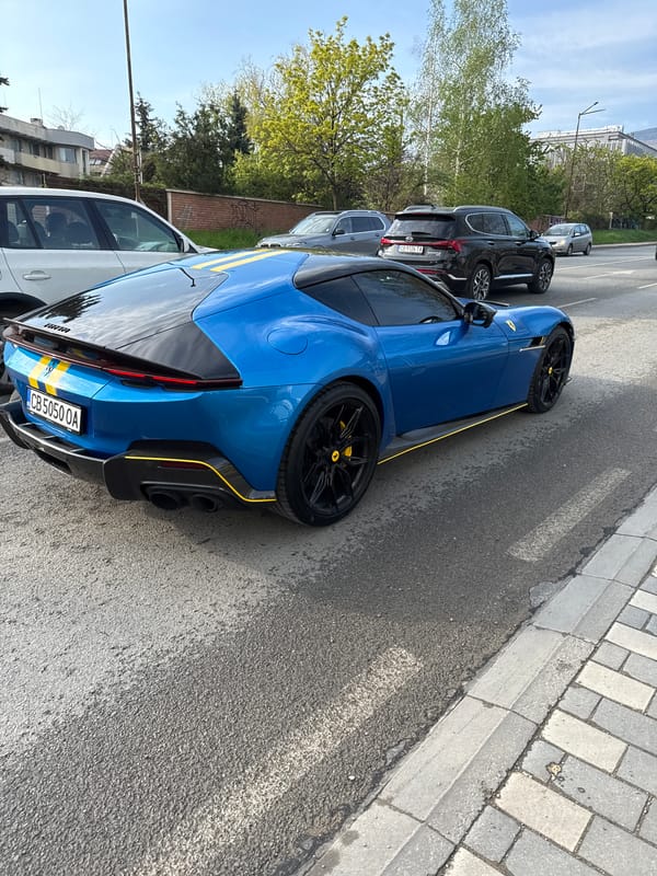 Blue Ferrari spotted on Sofia street amid mountain backdrop