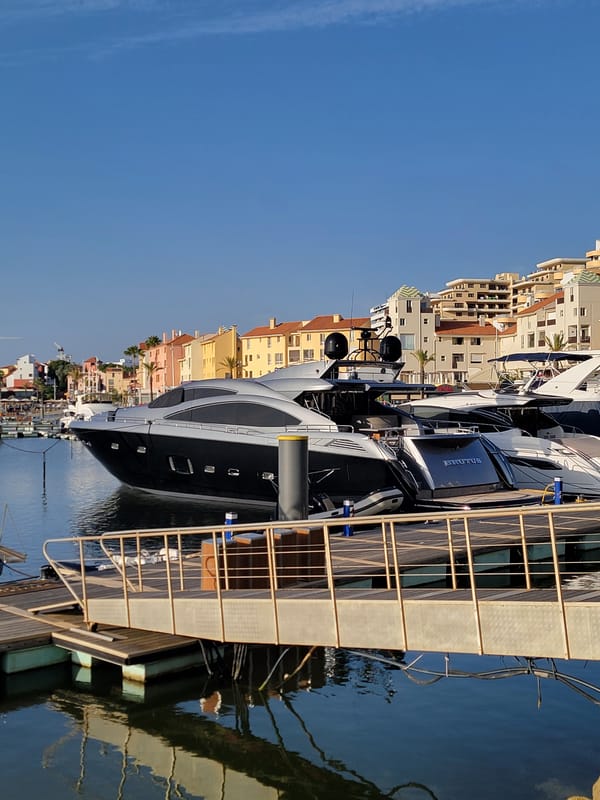 Evening at Quarteira marina — yachts, sculptures, and waterfront life