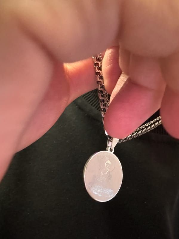 Silver Buddha pendant examined up close in Khimki